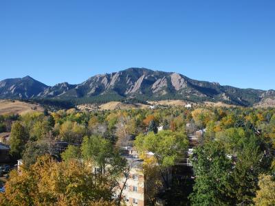 The Flatirons rising above leafy Boulder neighbourhoods in autumn