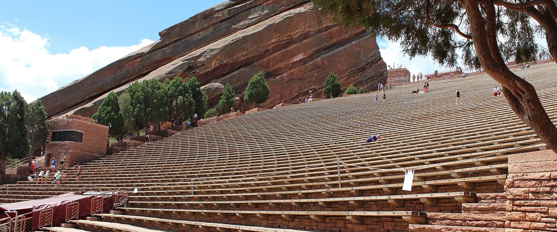 Tiered seating of Red Rocks Amphitheatre beneath a red sandstone monolith