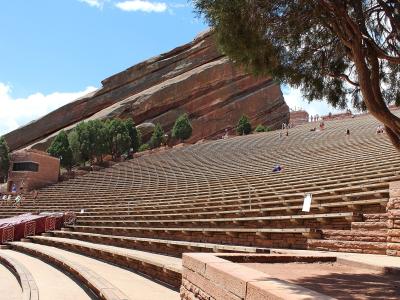 Tiered seating of Red Rocks Amphitheatre beneath a red sandstone monolith